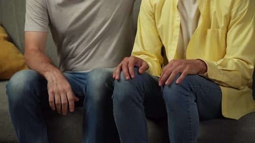 Close Up Video of a Homosexual Couple at Home The Men are Sitting on the Couch One Tries to Explain
