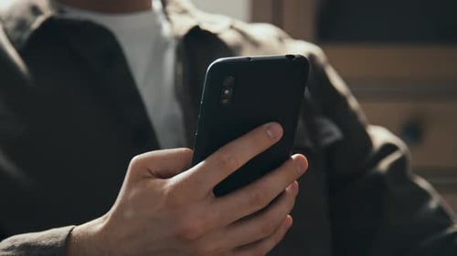 Man Checking Messages on Smartphone and Locking It