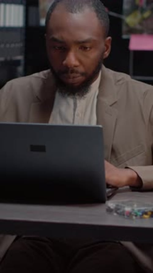 Man Working at Desk Looks Stressed