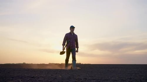 Bauer mit einer Hütte, die Pflanzen bei Sonnenuntergang auf dem Feld hält, erntet Landwirtschaft und pflanzt Samen