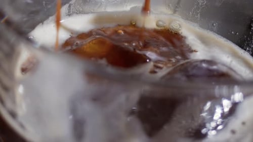 Brown Liquid Poured over Ice in Glass