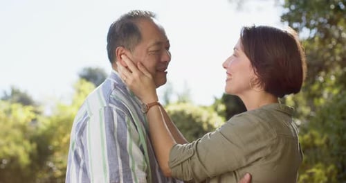 Loving Mature Couple Embraces in Sunlit Garden