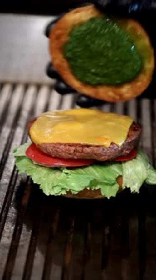 Juicy Cheeseburger Being Assembled on a Grill