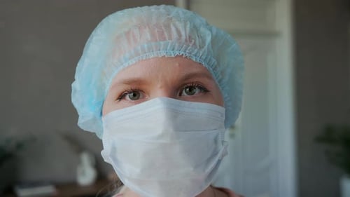 Close Up of Person Wearing Surgical Mask and Cap