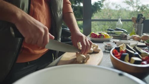 Mann schneidet Champignons auf der Außenterrasse