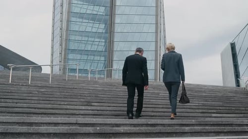 Entrepreneurs Going Upstairs in City Center with Skyscraper
