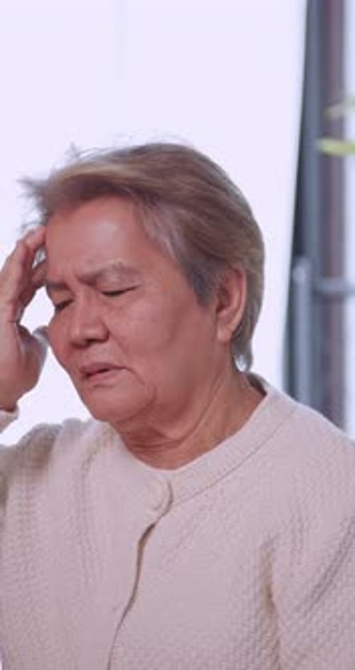 Senior Woman Massaging Temples Due to Headache