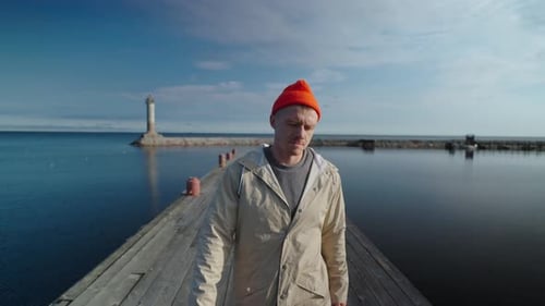 Marin marchant seul sur la vieille jetée dans une magnifique baie le matin, vue frontale SlowMotion