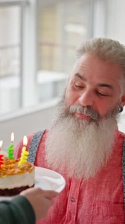 Bearded Senior Man Receives Birthday Cake with Candles