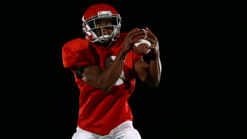 Focused Man Catches Football and Runs with It