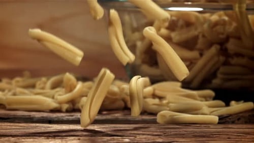 Dry Pasta Falls on a Wooden Table Filmed on a Highspeed Camera at 1000 Fps