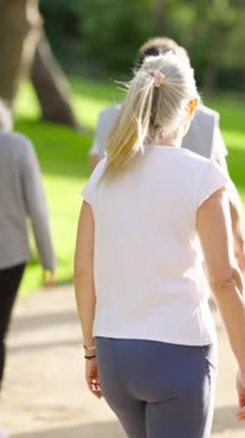 Mature Blonde Woman Walking in the Park for Exercise Vertical