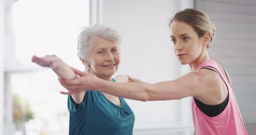 Senior Woman Practicing Yoga with Instructor