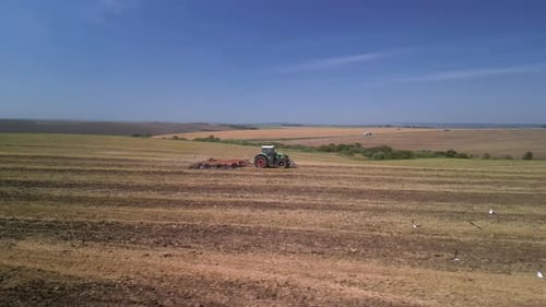 Tractor working on the field doing tillage with cultivator