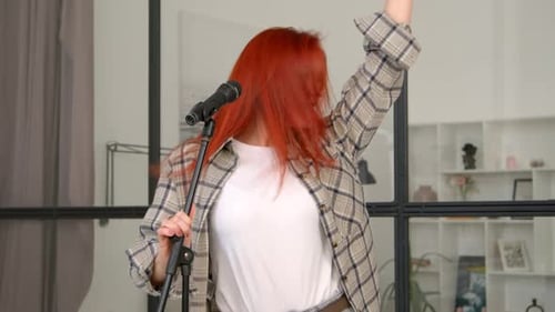 Energetic Woman Singing with Microphone Indoors