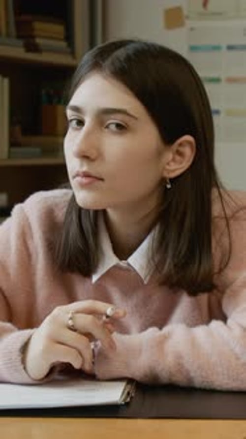 Portrait of Demure Teenage Girl Writing Trimester Test at Lesson in High School