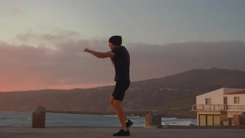 Sporty Man Practicing Air Boxing By Sea at Sunset