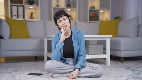 Woman Thinking Deeply Sitting on Living Room Floor