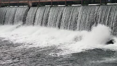 cascada de una presa que salpica las rocas y provoca neblina