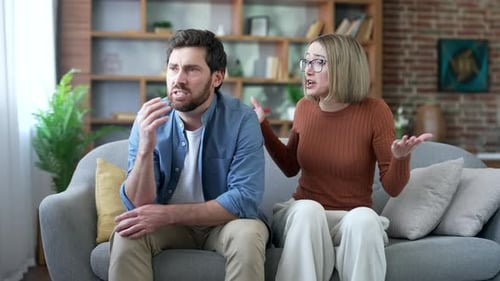 Upset Couple Arguing on a Couch at Home