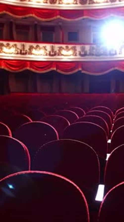 Empty classic theater. Rows of empty red velvet seats inside a theater or opera.