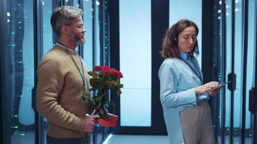 A Man Holding Beautiful Flowers in a Modern Office Setting Exuding Joy and Positivity