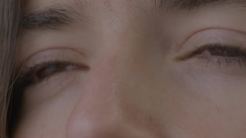 Extreme Nahaufnahme des intensiven Blicks einer Person. Junge Frau schöne haselnussbraune Augen