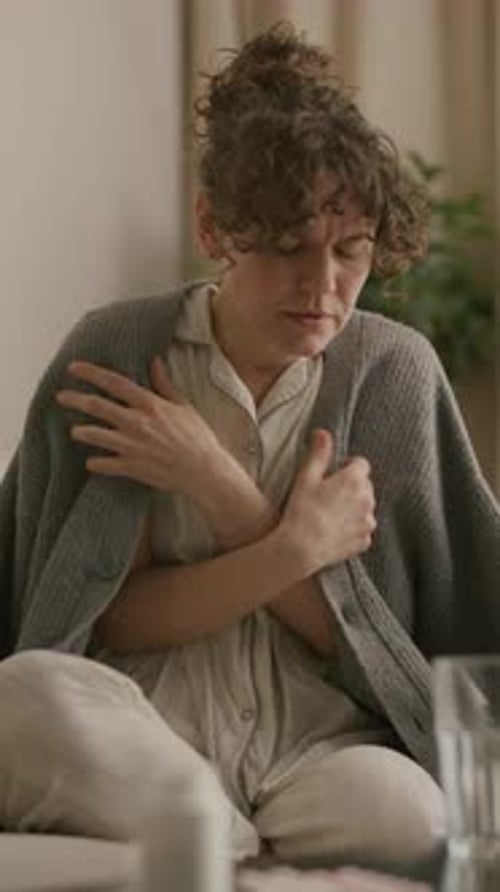 Woman in Pajamas Coughing Checks Pregnancy Test Results