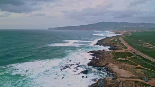 Aerial View Rugged Coastline with Crashing Turquoise Waves Wild Green Terrain