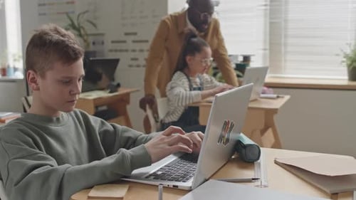 Schoolboy Coding on Laptop during Programming Lesson