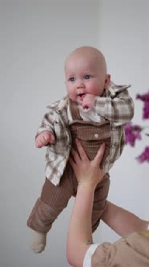 Baby Held by Mother Indoors