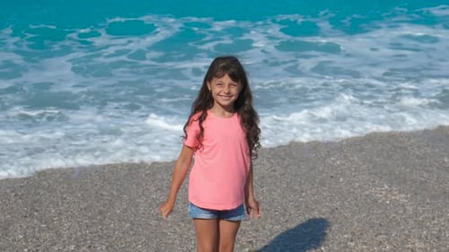 Young Girl Spinning Happily on Sandy Beach