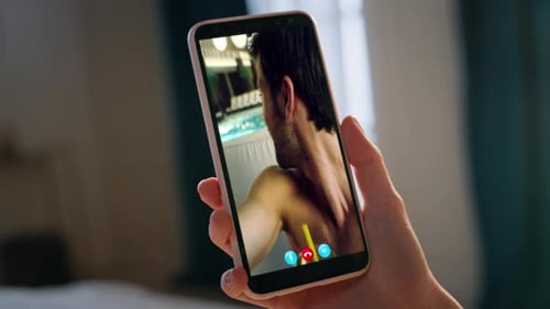 Woman Holds Phone Showing Man Video Chatting by Pool
