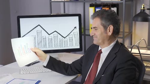 Erfolgreicher Geschäftsmann analysiert Finanzdiagramme und ist glücklich.