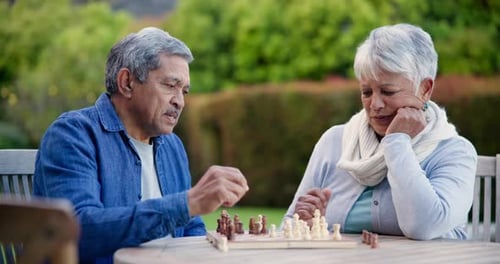 Senior man, woman and chess in park for competition, contest or problem solving at table in nature