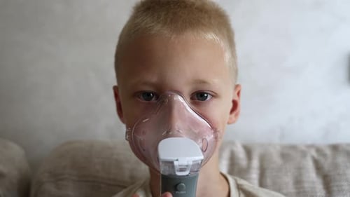Young Boy Using Nebulizer for Respiratory Treatment