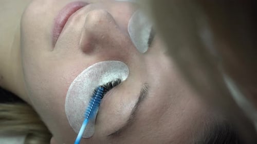 Woman Receiving Eyelash Extensions in Beauty Salon