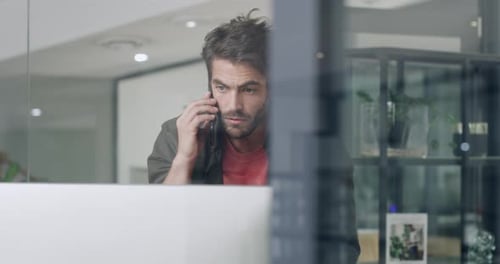 4k-Videomaterial eines jungen Geschäftsmannes mit Smartphone und Computer in einem modernen Büro