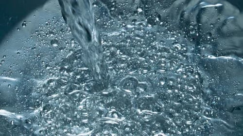 Soda Blebs Floating Aqua Surface Closeup. Mineral Water Pouring Transparent Glass Macro
