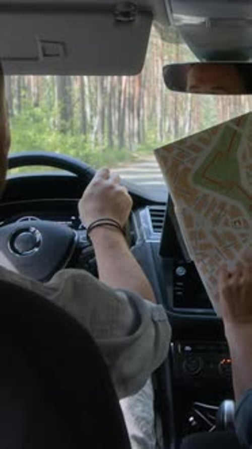 Car Driving on Road with Two Adults Reading Map