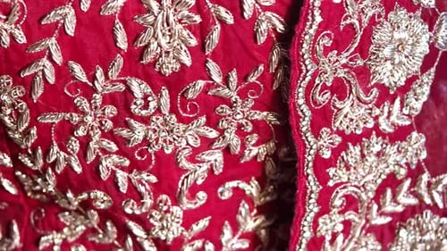 Elegant Red Embroidered Fabric Showcasing Intricate Golden Designs