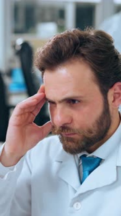 Bearded Man in Lab Coat Deep in Thought