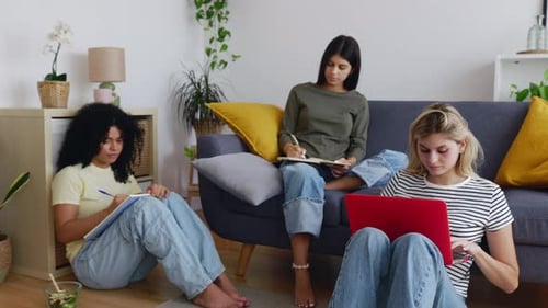 Three Young Friends Studying Together in Bright Home
