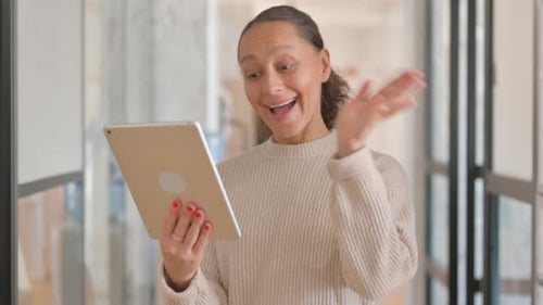 Woman Smiling and Using a Tablet Computer