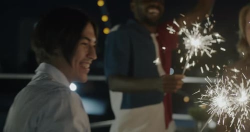 Friends Celebrating at Night with Sparklers on Rooftop