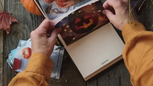 Manos femeninas colocan fotos impresas de otoño en un álbum de fotos