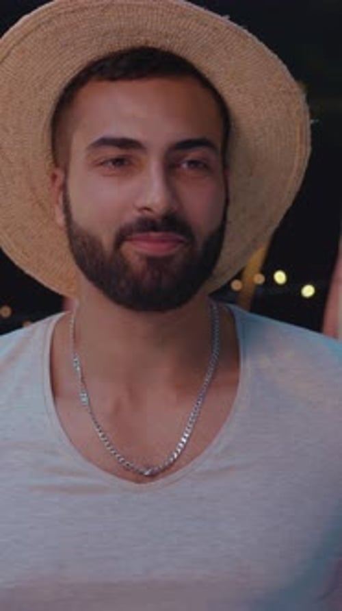 Smiling Man Wearing Hat at Night