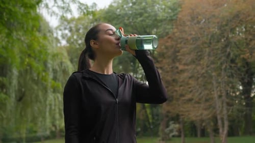 Sport Woman Caucasian Fitness Girl After Workout in City Park Drink Bottle Fresh Water Happy Female