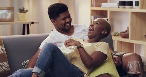 Laughing Couple Sharing Popcorn at Home