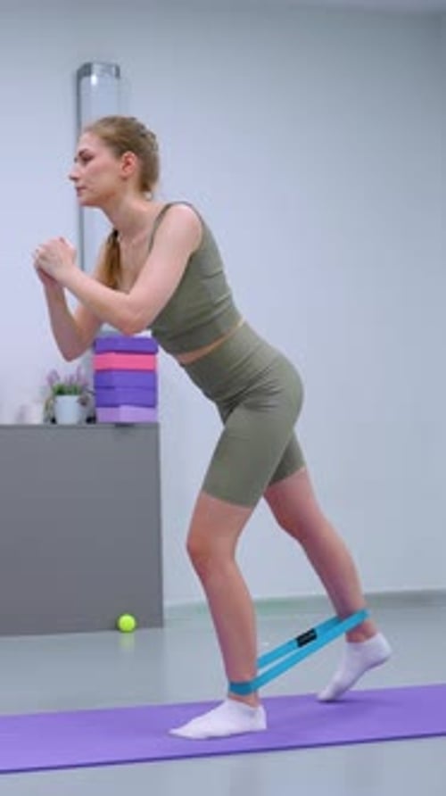 Remote Worker Stretches with Resistance Band in Modern Gym